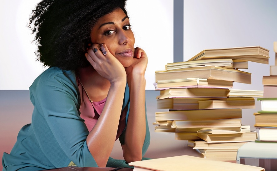 femme à côté d'une pile de livres